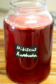 a jar filled with liquid sitting on top of a wooden table