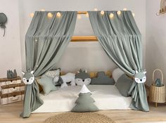 a child's bed with curtains and stuffed animals on it