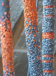 three orange and blue vases sitting next to each other