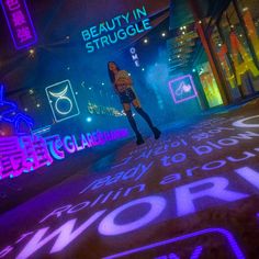 a woman standing in the middle of a street at night with neon signs all around her