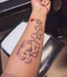 an elephant tattoo on the arm with hearts coming out of it's back end