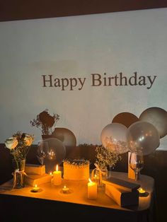 a table with candles and balloons on it