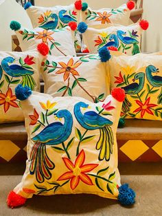 colorful pillows with pom poms and flowers on them