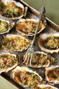 a tray filled with lots of oysters covered in sauce