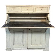 an old white wooden desk with drawers and cupboards on the top, against a white background