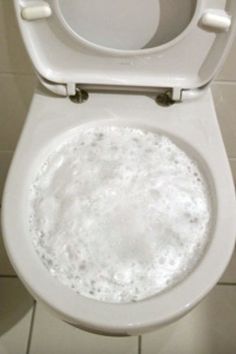 a white toilet with the lid up and water in it