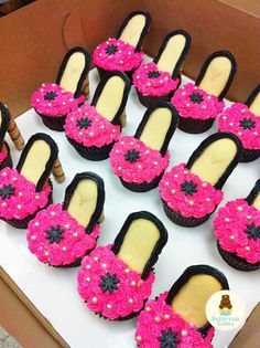 cupcakes decorated with pink and black icing in the shape of women's shoes