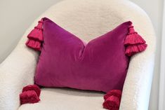 a white chair with a purple pillow on it