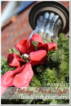 an outdoor holiday light with red bows on it