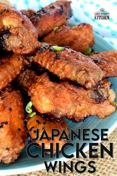 a plate full of fried chicken wings with seasoning on the side and garnished with scallions