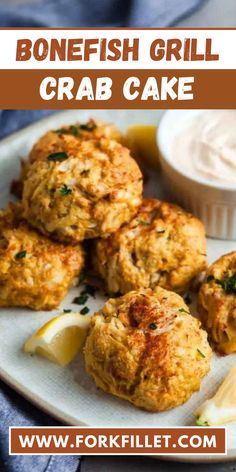 crab cakes on a white plate with lemon wedges