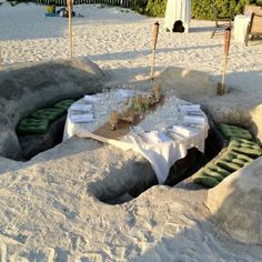 a table set up in the middle of some sand