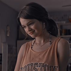 a young woman in a tank top looking at her cell phone