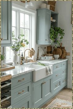 a kitchen filled with lots of blue cabinets and white counter tops next to a window