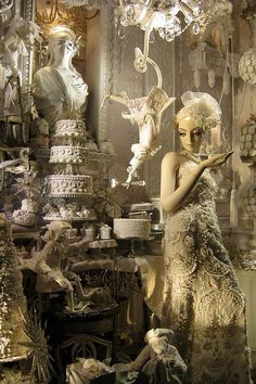 a mannequin dressed in an elaborate dress holding a cake