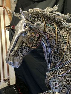 an intricately designed horse is shown in front of a black backdrop with other items