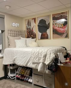 a bed sitting in a bedroom next to two pictures on the side of a wall