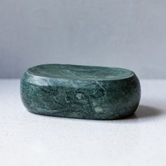 a green marble box sitting on top of a white table