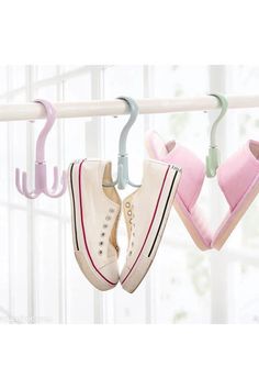 two pairs of shoes hanging from a rail