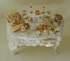 a white table topped with lots of different types of jewelry on top of a lace covered table