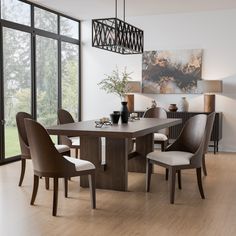 a dining room table and chairs in front of large windows