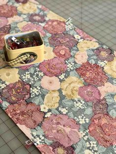 a flowered table cloth with a yellow container on it and some candy in the middle