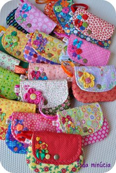 many colorful purses are lined up together on the floor and ready to be used