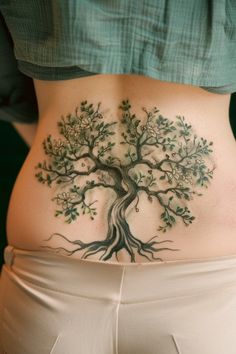 a woman's stomach with a tree tattoo on her belly and the bottom part of her lower body