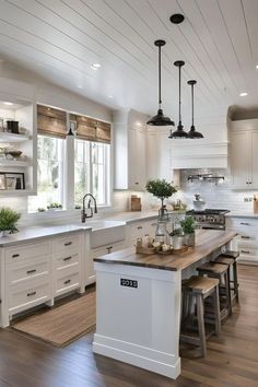 a large kitchen with white cabinets and wooden flooring, along with an island in the middle