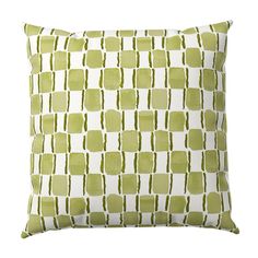 a green and white pillow with square shapes on the front, in an off - white background