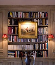 a room with bookshelves and a painting on the wall