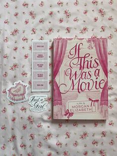 there is a pink book and some stickers on the bed with it's cover