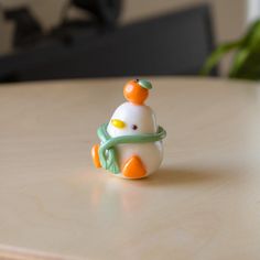 a small toy duck sitting on top of a wooden table