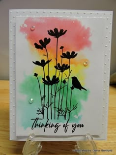 a card with some flowers on it and the words thinking of you written in black