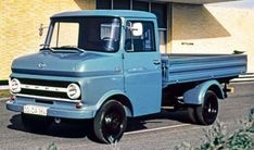 an old blue truck parked in front of a building