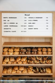 breads and pastries are on display in the bakery's display case,