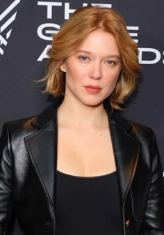 a woman with blonde hair wearing a black leather jacket