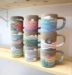 four coffee cups sitting on top of a shelf