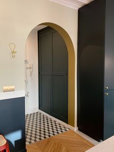 a black and white checkered floor in a room with an arched doorway to another room