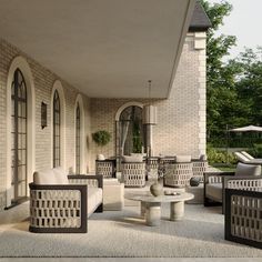 an outdoor living area with white furniture and large windows on the side of the building