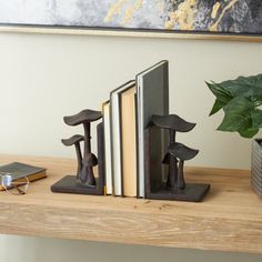 two bookends are sitting on a shelf next to a potted plant and books