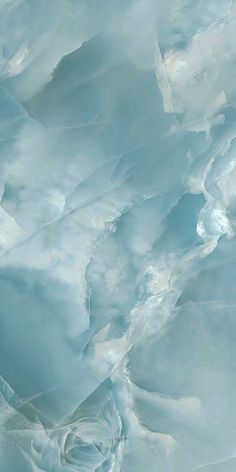 an aerial view of some ice formations in the water with blue sky and clouds above