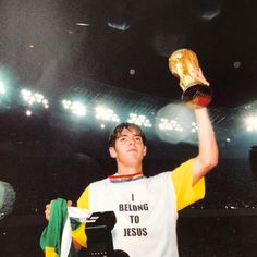 a young man holding up a trophy in front of an audience at a sporting event