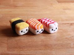 two small sushi dolls sitting on top of a wooden table