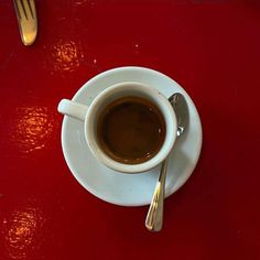 a cup of coffee on a saucer with a spoon