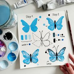 someone is painting butterflies with watercolors on paper