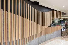 the interior of a restaurant with wooden slats on the wall and marble flooring