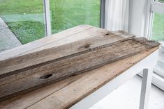 a wooden bench sitting in front of a window