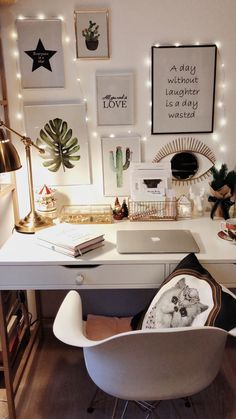 a white desk topped with a laptop computer and lots of pictures on the wall above it