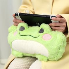 a person holding a green stuffed animal with a tablet in their lap